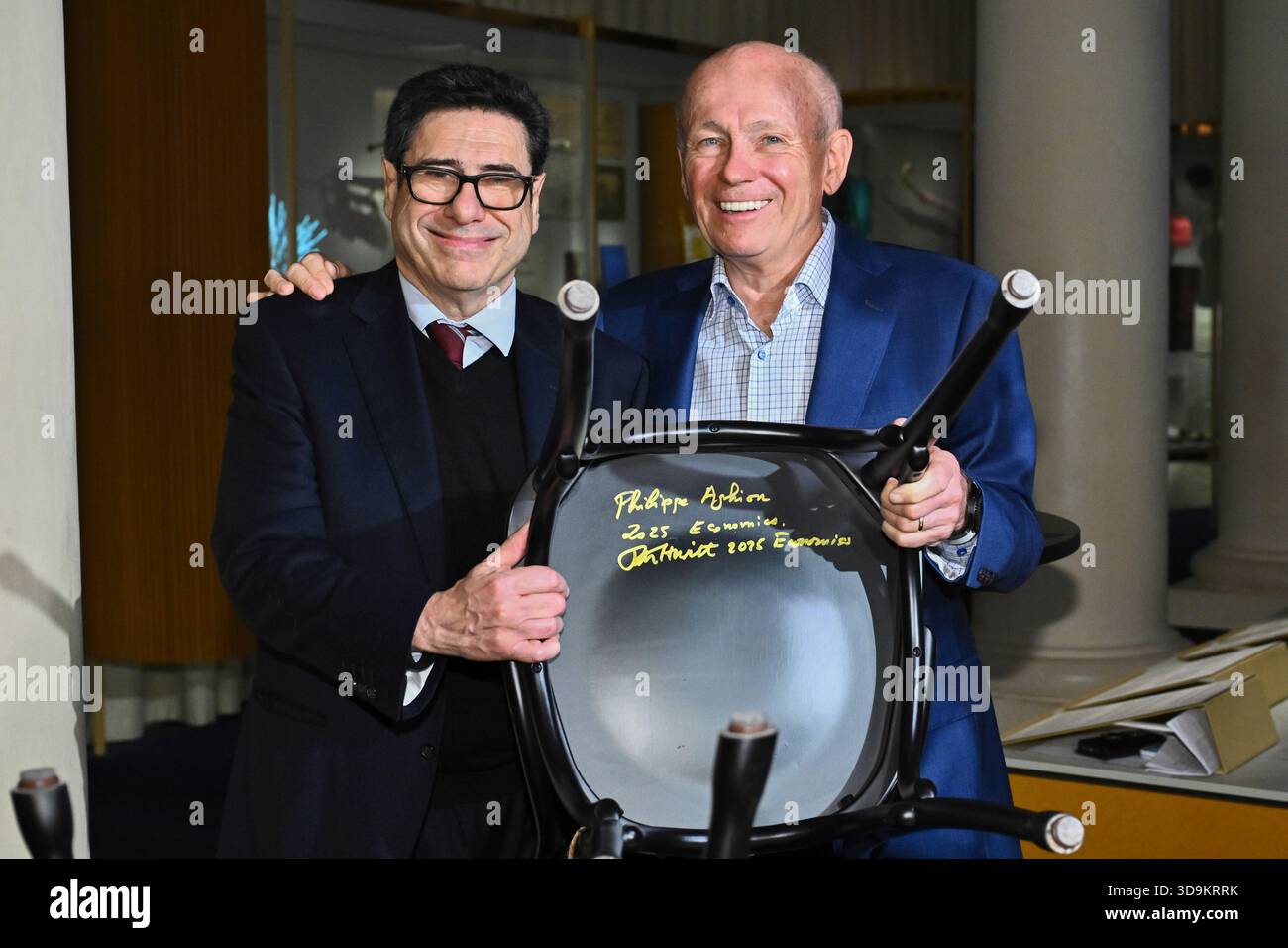 Philippe Aghion, left, and Peter Howitt, laureates in economics, show their signature on a Nobel Chair at the Nobel Museum in Stockholm, Sweden, Saturday, Dec. 6, 2025. (Claudio Bresciani/TT News Agency via AP) Stockfoto