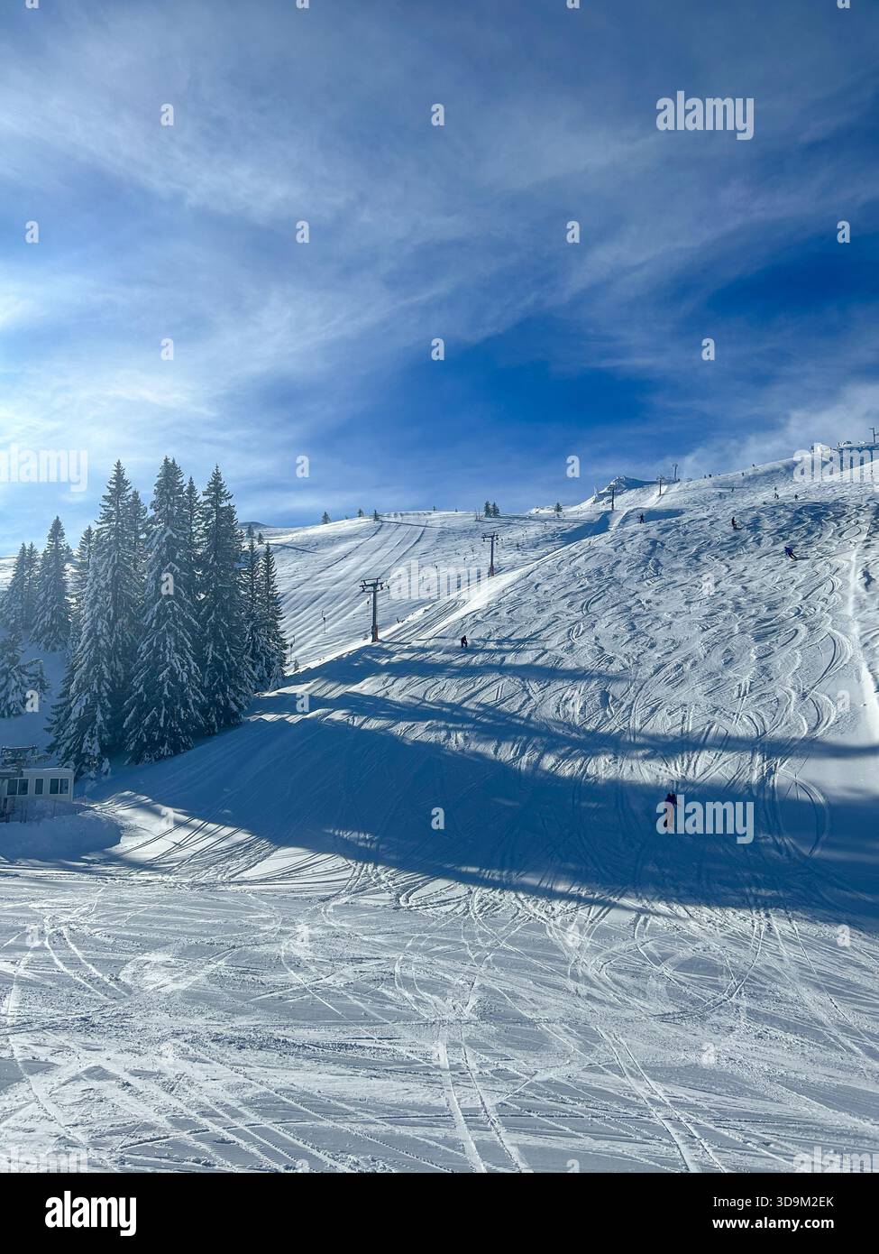Skifahrer auf den verschneiten Pisten von Jahorina, Bosnien und Herzegowina, fotografiert am 3. Februar 2023. Klares Wetter hebt diese bekannte Olympiastadt hervor - Smartphone-aufgenommenes Stockfoto