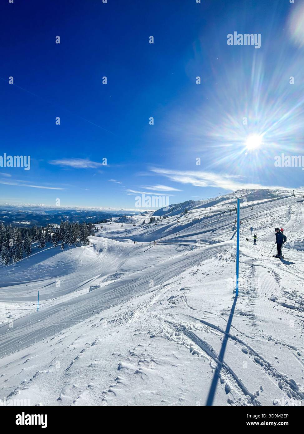 Skifahrer auf den schneebedeckten Pisten von Jahorina, Bosnien und Herzegowina, am 3. Februar 2023 gefangen. Bei klarem Wetter sind die beliebten Olympischen Berge zu sehen - Smartphone-aufgenommenes Stockfoto