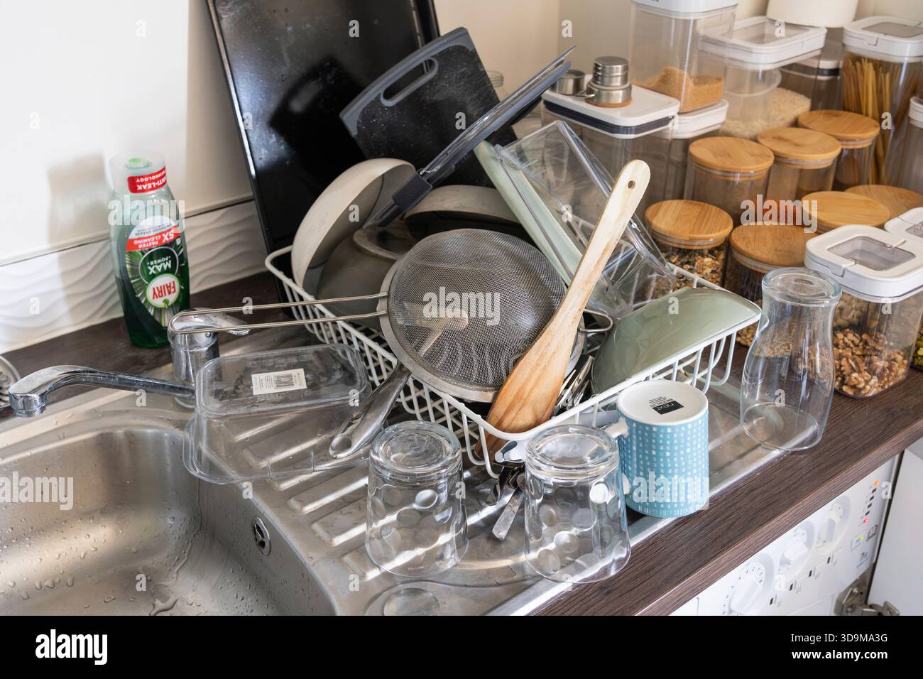 Überlaufendes Geschirr auf einem Küchenregal in einer Küche nach dem Abwaschen von Hand, mit einer Feenflüssigkeit Spülflasche, England Stockfoto