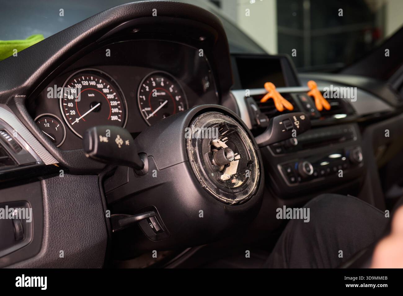 Detaillierte Fahrzeugreparatur, fokussierte Handaufnahme zur sorgfältigen Wiederherstellung des Lenkungsbauteils des Fahrzeugs, Präzisionsarbeiten am Lenkrad des Fahrzeugs mit Werkzeugen in Stockfoto