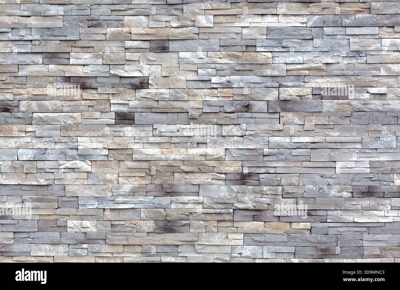 Weite Sicht auf eine Außenwand aus Reihen von Steinblöcken. Stockfoto
