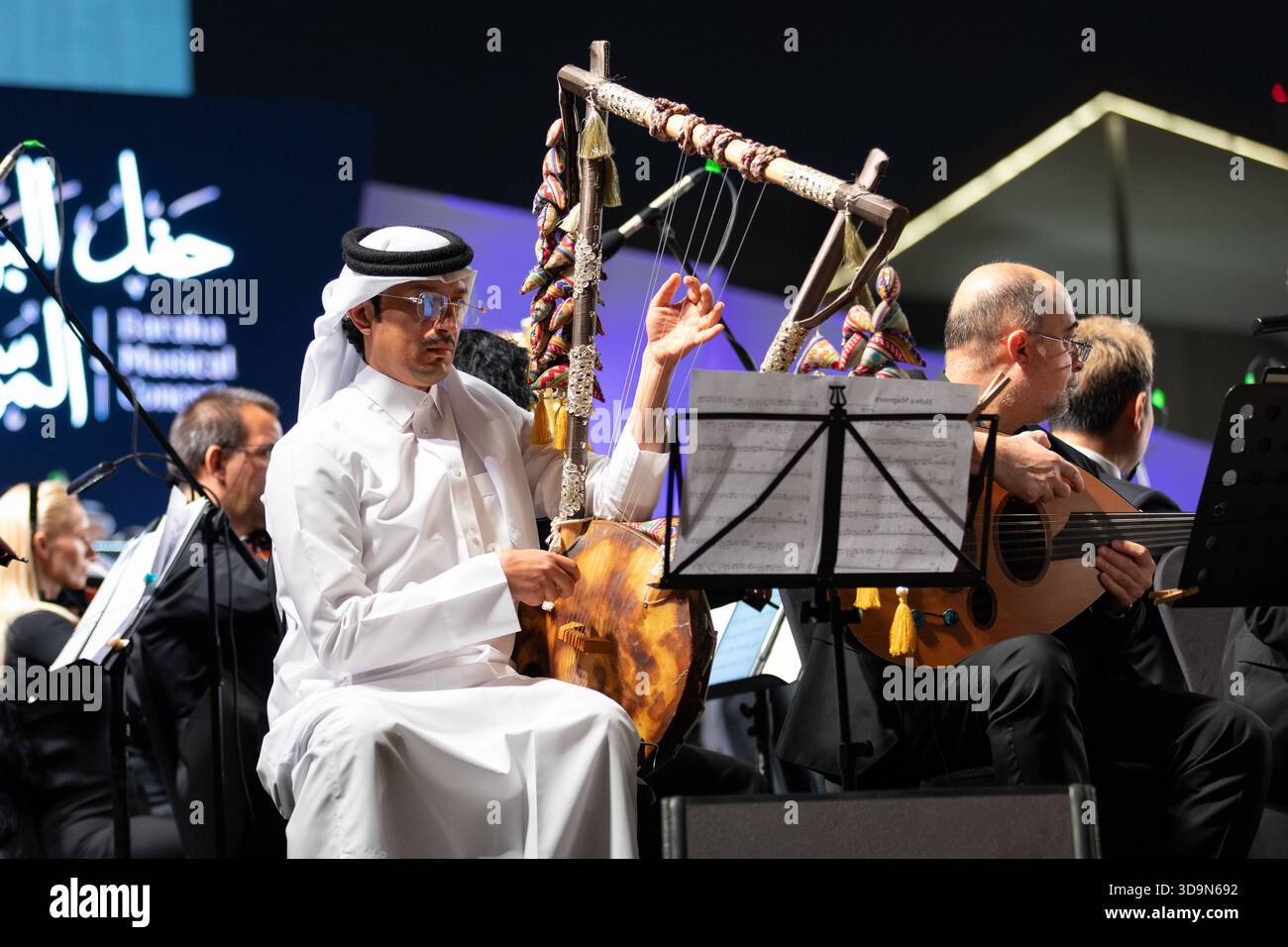 Ein katarischer Mann, der auf einem Semsemia (Simsimiyya)-Musikinstrument spielt. Tritt während des Baraha Musical Concert 2025 im Msheireb Downtown Doha auf Stockfoto