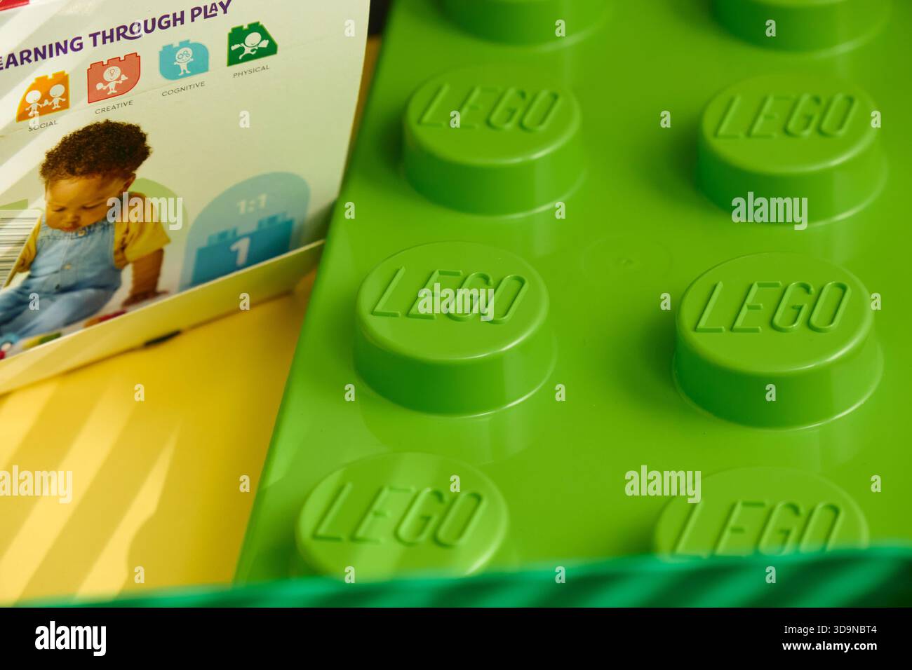 Tyumen, Russland-8. Juli 2025: Ein lebhafter, grüner Baustein Lego wird vor einer hellen und farbenfrohen Kulisse sichtbar. Stockfoto