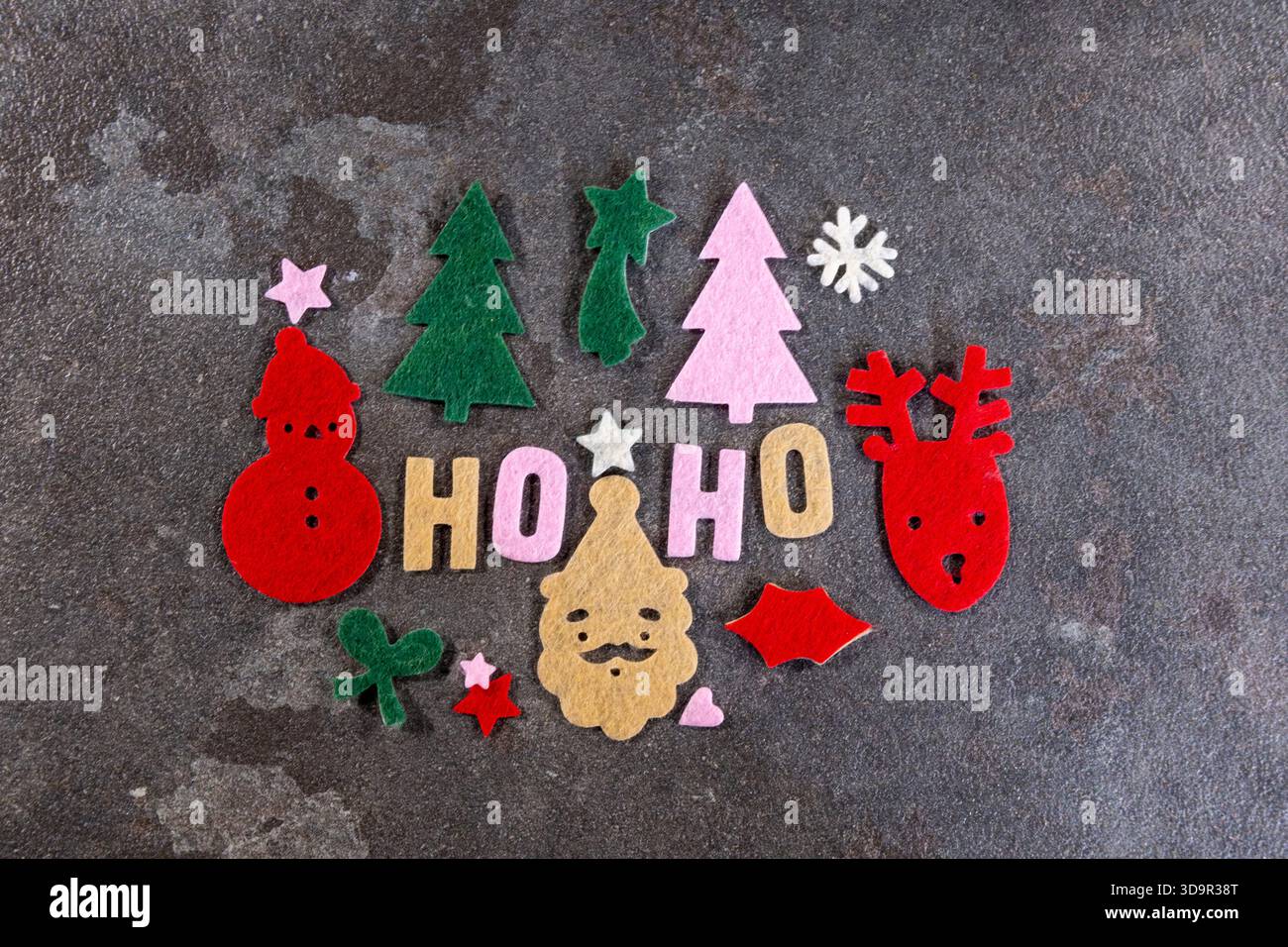 Bunte Filzformen feiern den Feiertagsgeist. Zu den festlichen Motiven gehören Schneemänner, Bäume, Rentiere und Weihnachtsmann, perfekt zum Basteln von Dekorationen Stockfoto