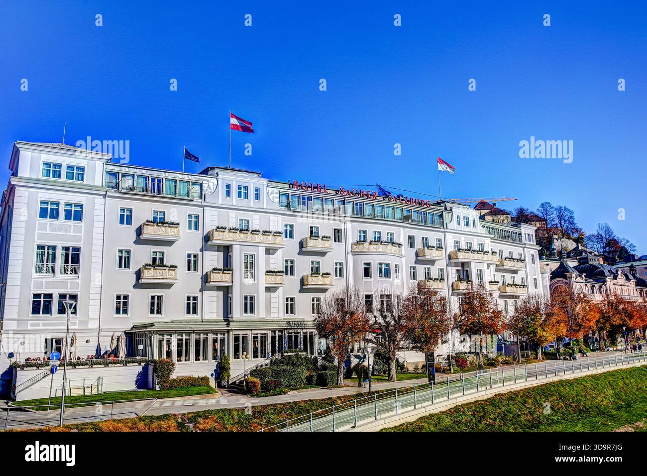 Das Hotel Sacher Salzburg liegt an der Salzach in hellen Herbstfarben. Stockfoto