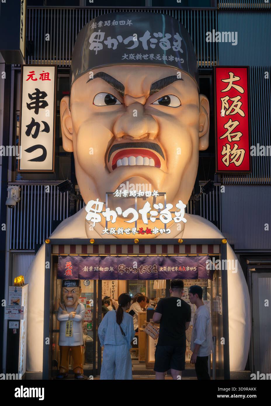 Dotonboris lebendige Essensszene wird durch das aufragende, wütende Maskottchen von Kushikatsu Daruma und andere beleuchtete Straßenschmeckschilder verkörpert Stockfoto