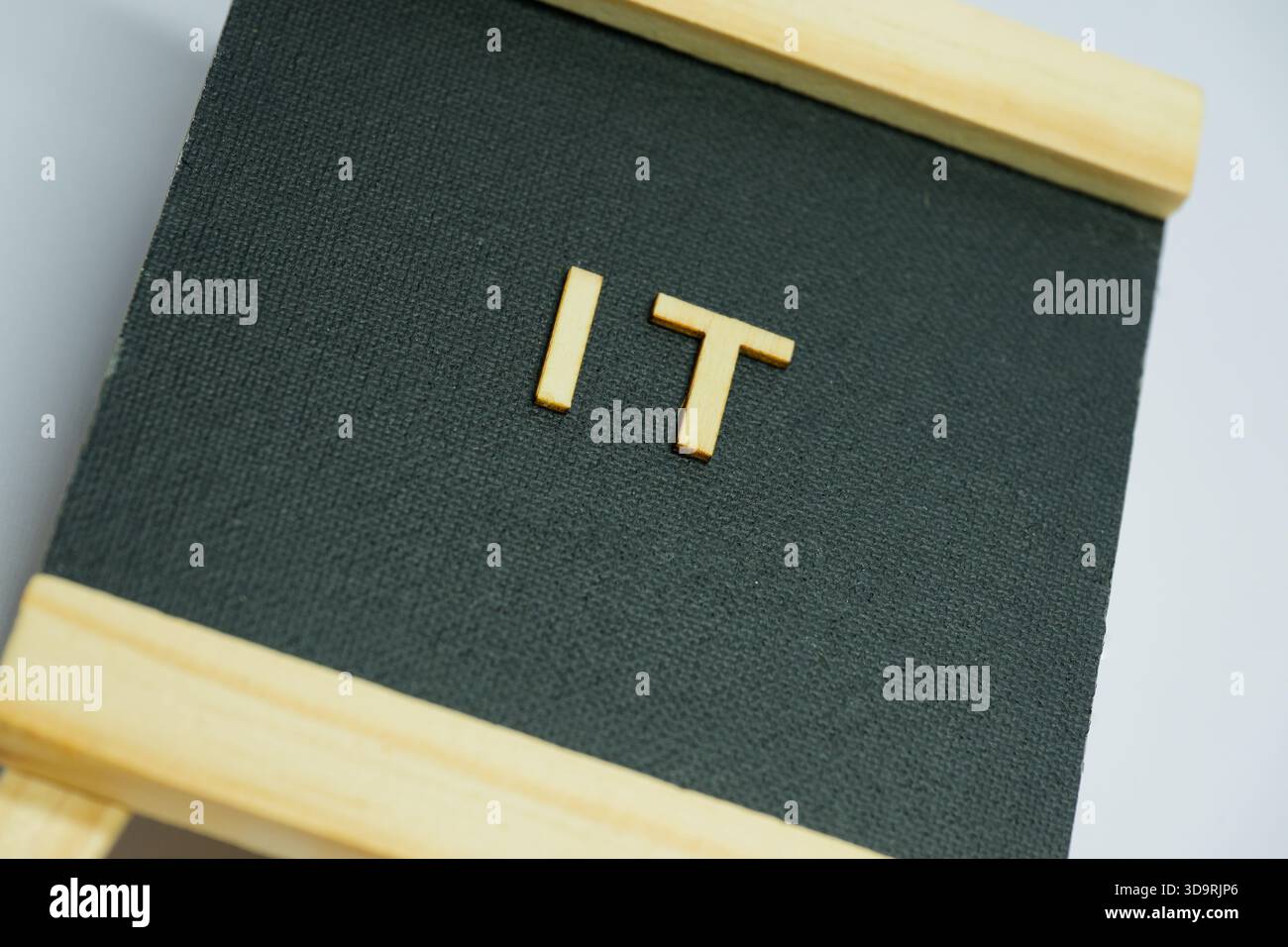 Einfache Holzbuchstaben, die das Wort „ES“ bilden, werden auf einem schwarzen Stoffhintergrund platziert. Eine symbolische und stilvolle Grafik, die mit Digital, Software oder Technik verknüpft ist Stockfoto