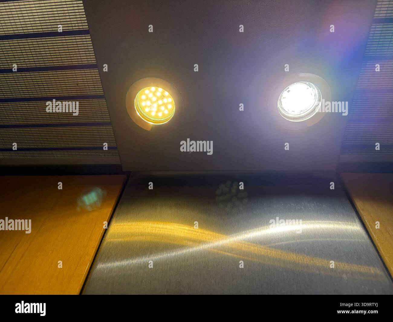 Zwei moderne LED-Deckenleuchten mit warmem und kühlem Farbkontrast aus nächster Nähe. Perfekt für Architekturgrafiken, Beleuchtungskonzepte oder Smart Stockfoto