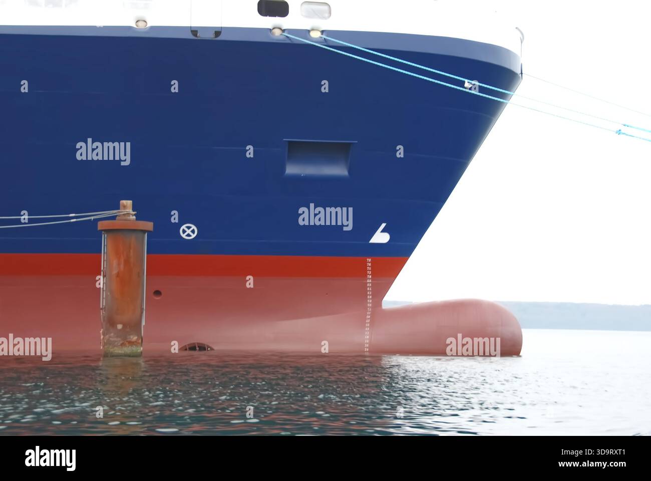 Eine Nahaufnahme des Schiffskörpers, der teilweise in Wasser getaucht ist, zeigt die blauen und roten Farben des Schiffes. Das Bild zeigt die Struktur des Schiffes Stockfoto