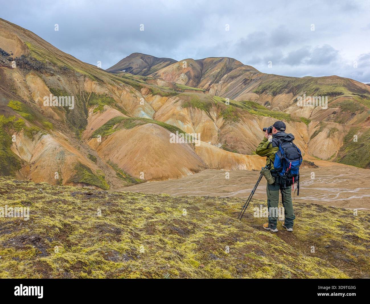 Wanderer fotografieren die riesigen, farbenfrohen Rhyolith-Berge und den silbrigen Talboden im isländischen Hochland. Stockfoto