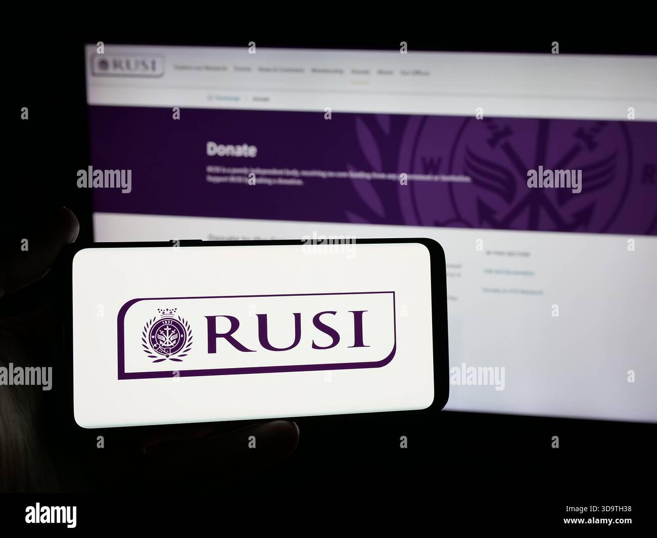 Stuttgart, Deutschland - 24.11.2025: Person, die ein Smartphone mit dem Logo des Royal United Services Institute (RUSI) auf dem Bildschirm vor der Website hält. Stockfoto