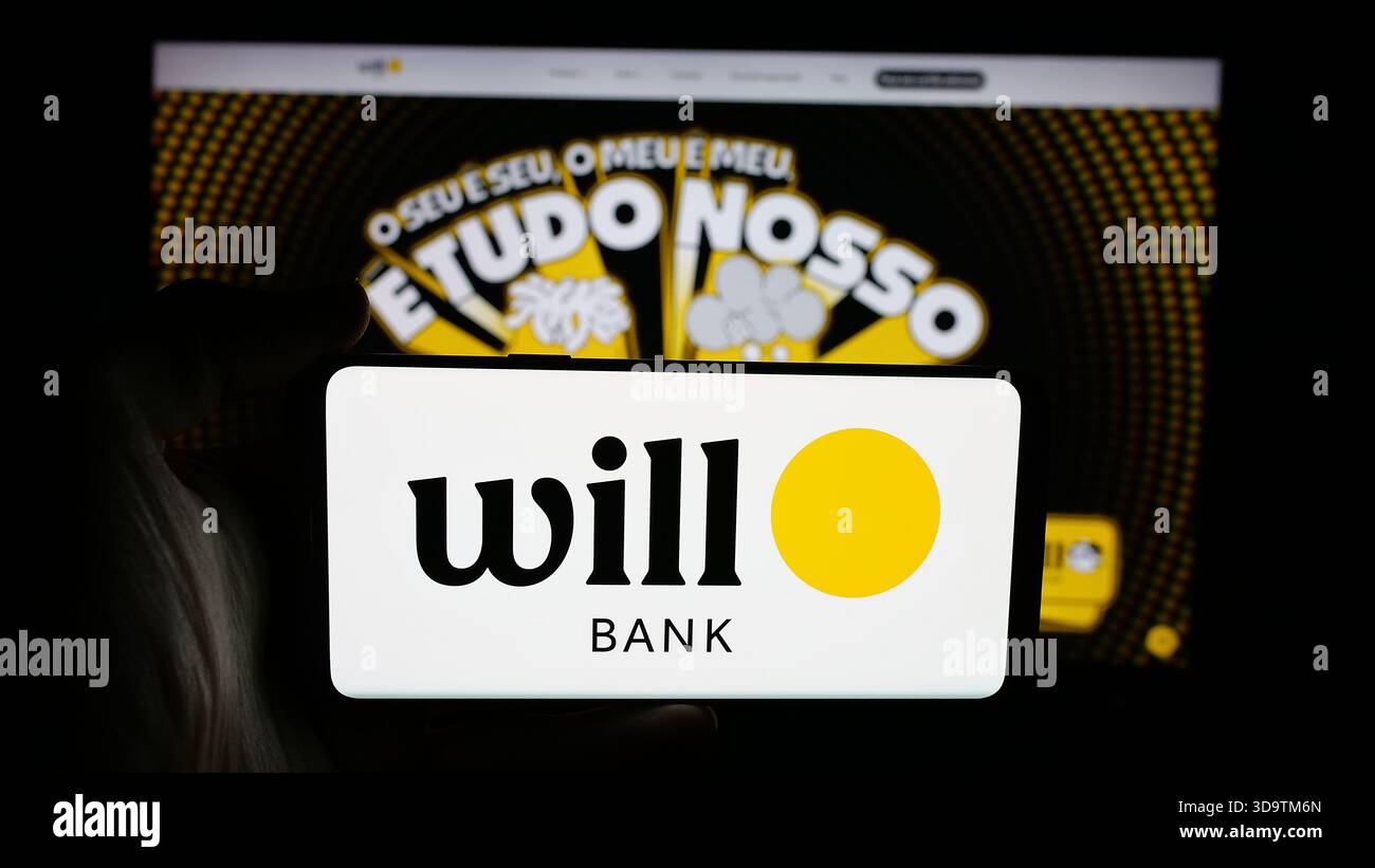 Stuttgart, Deutschland - 28.11.2025: Person, die ein Mobiltelefon mit dem Logo der brasilianischen Bank hält, will Financeira S.A. auf dem Bildschirm vor der Webseite. Stockfoto