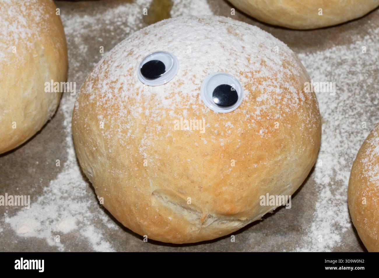 Ein lustiges frisch gebackenes Brötchen mit wackeligen Augen Stockfoto