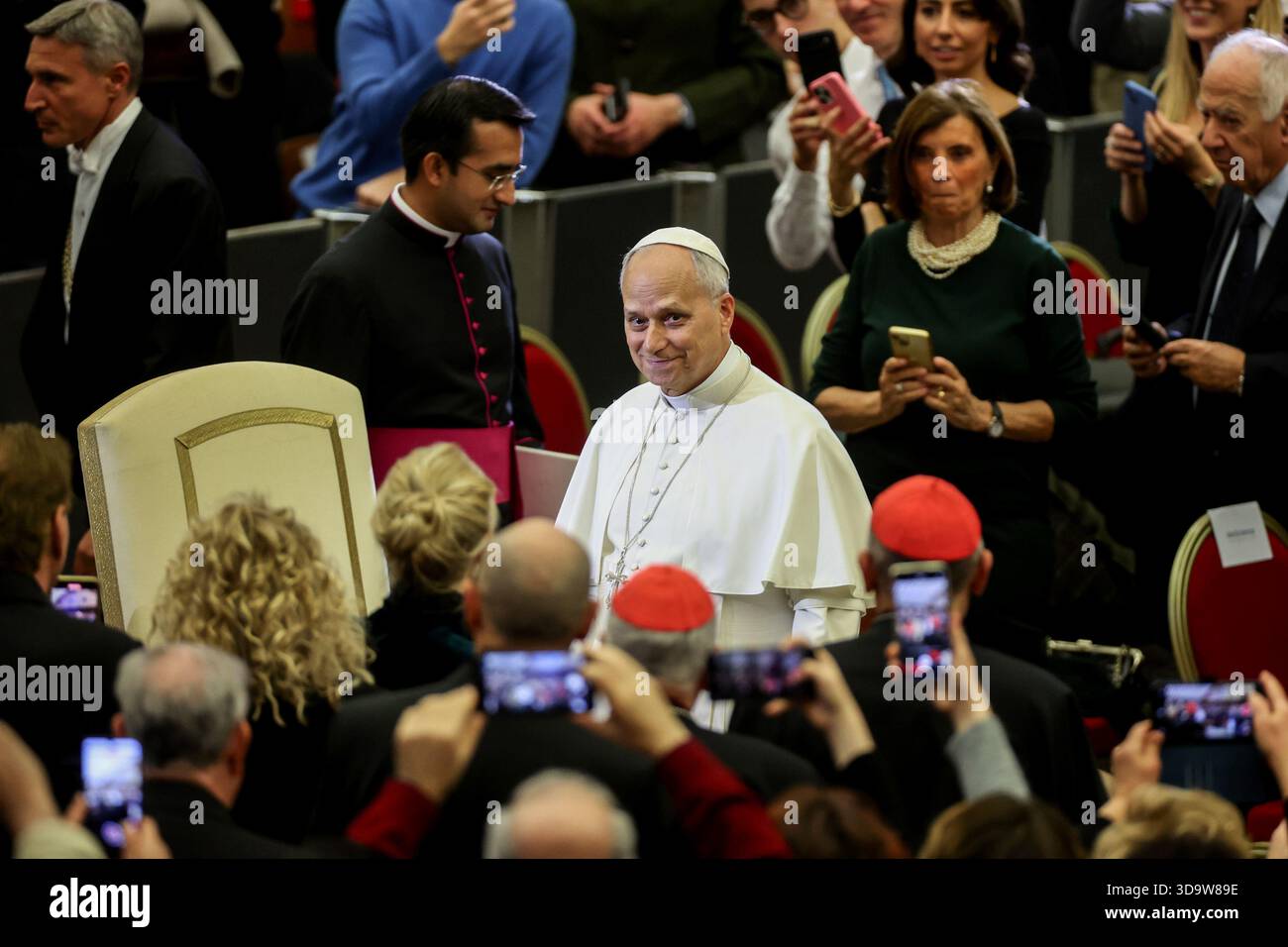 Vatikan, Italien. Dezember 2025. Papst Leo XIV. Kommt in den Saal und begrüßt die Gäste. Papst Leo XIV. Nahm an dem Konzert für die Armen Teil, das im Vatikan mit einem Auftritt des kanadischen Sängers Michael Steven Buble und der Sängerin Serena Autieri im Paul VI. Saal organisiert wurde. (Foto: Marco Iacobucci/SOPA Images/SIPA USA) Credit: SIPA USA/Alamy Live News Stockfoto