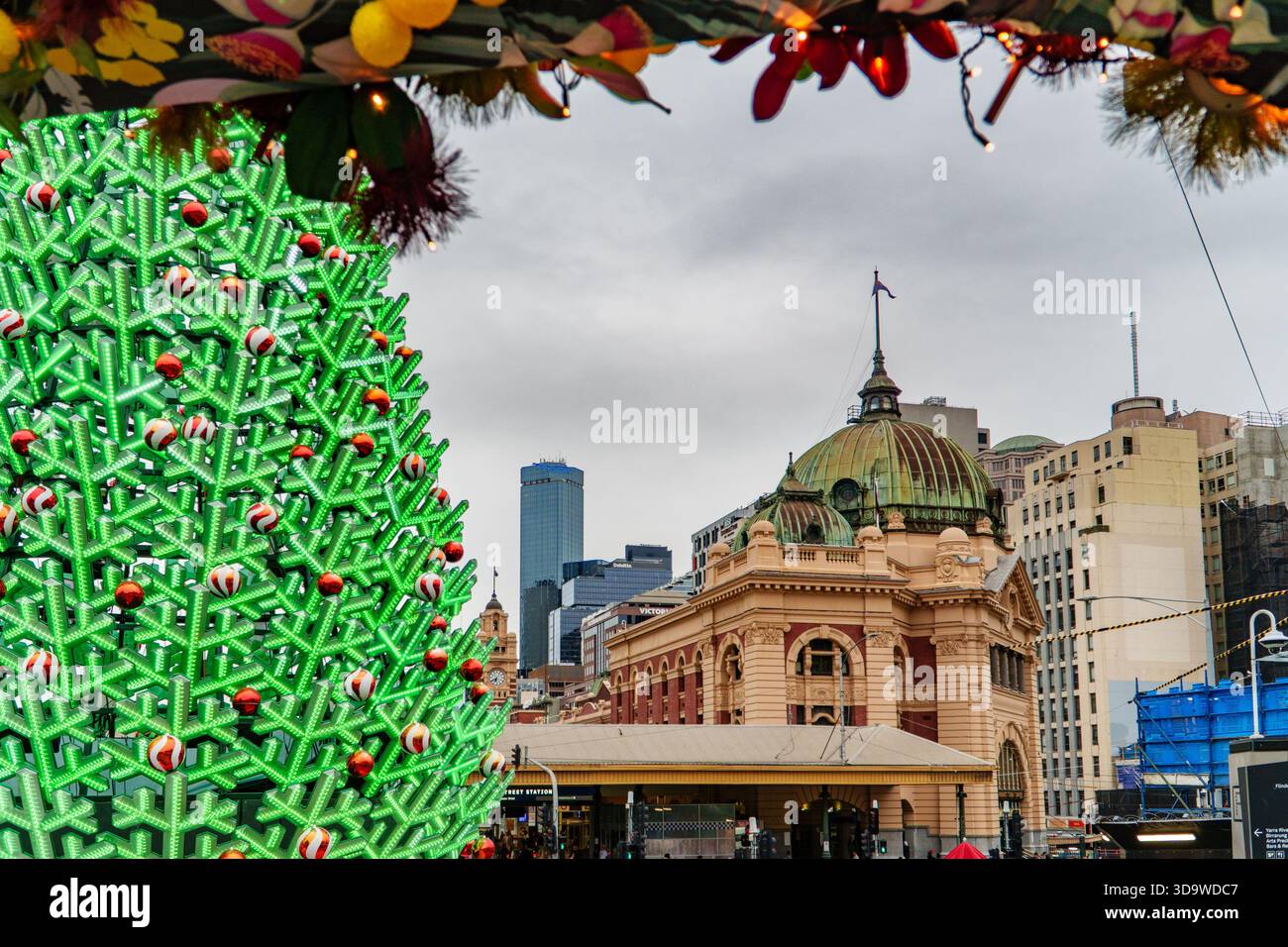 Melbourne, VIC, Australien. Dezember 2025. - Ein beleuchteter, moderner Weihnachtsbaum steht vor der historischen Flinders Street Stati Stockfoto