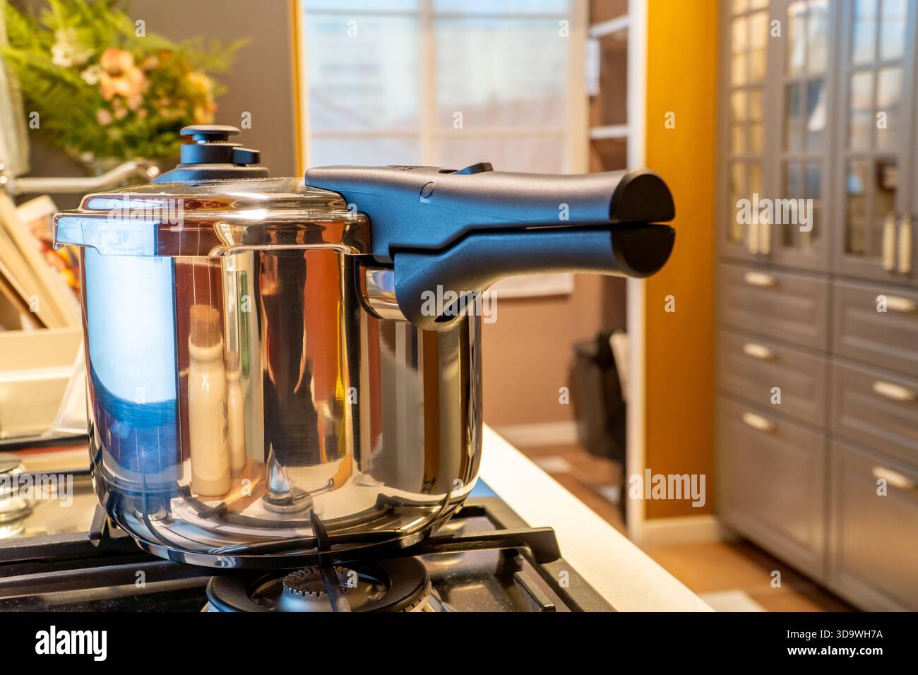 Druckkochfeld für energieeffizientes Kochen auf Gasherd in einer klassischen Küche, die von fossilen Brennstoffen abhängig ist Stockfoto