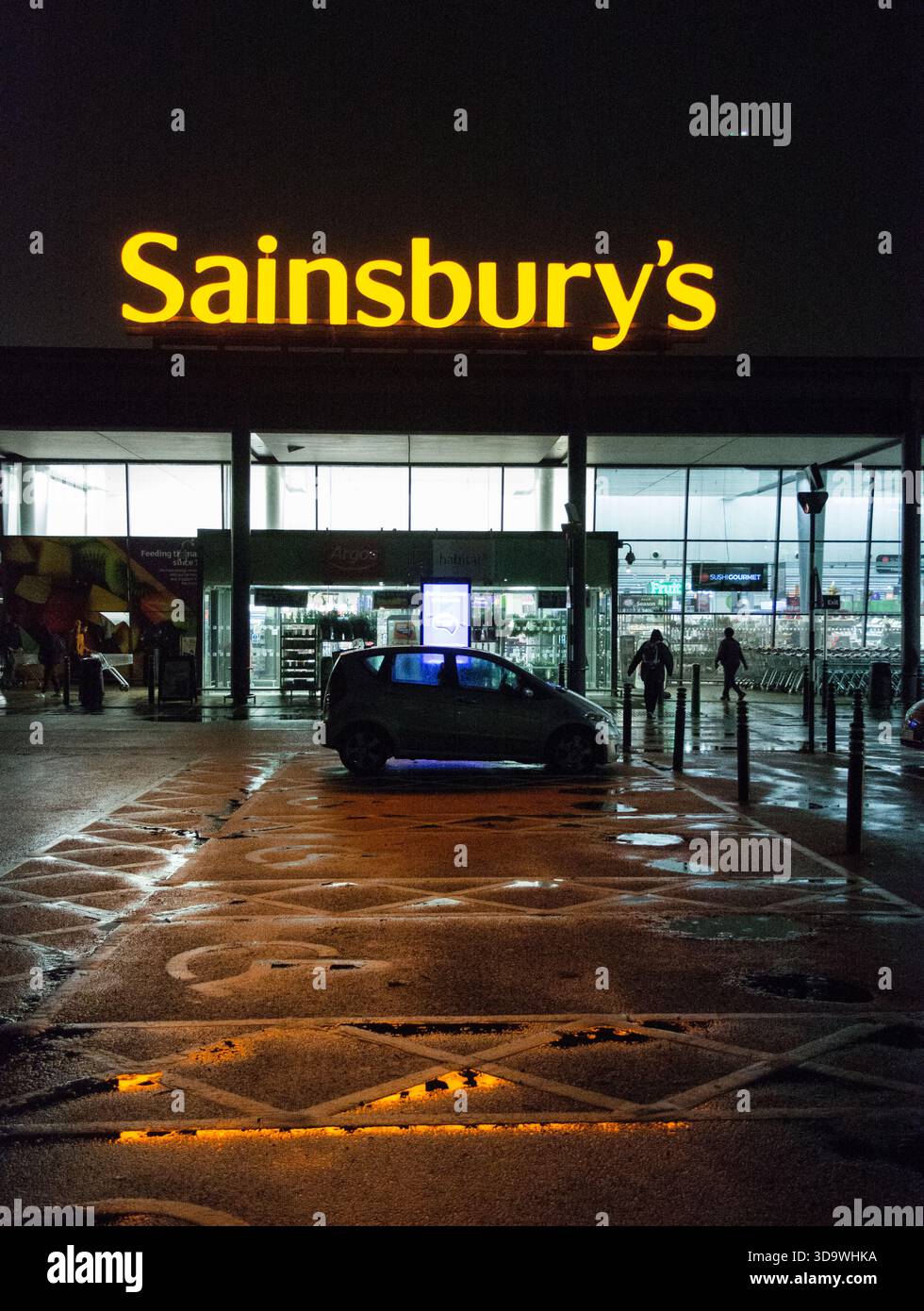 Beleuchtete Beschilderung über dem Eingang zu Sainsbury's an der Lower Richmond Road, Richmond, London, England, Großbritannien Stockfoto