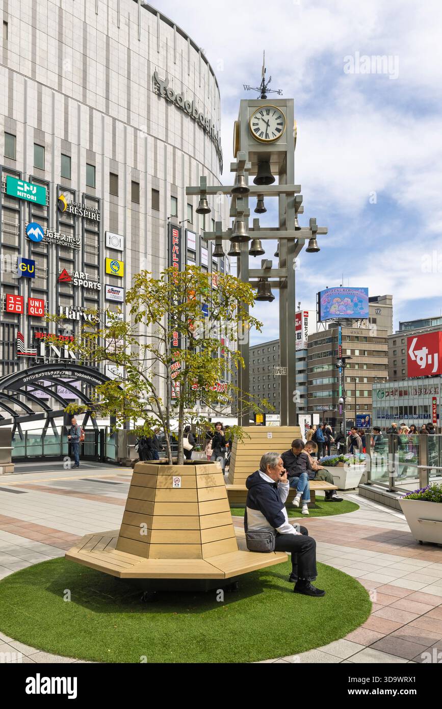 Osaka, Japan - 31. März 2025: Japaner ruhen auf einer Holzbank im Zentrum des JR-Bahnhofs in Osaka in Japan Stockfoto