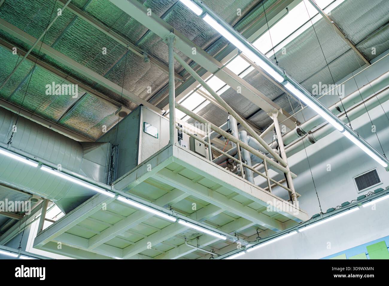 Industriedecke mit Lüftungssystem mit Kanälen, HLK-Einheit, Isolierung und Metallrohren im Innenraum der Fabrik Stockfoto