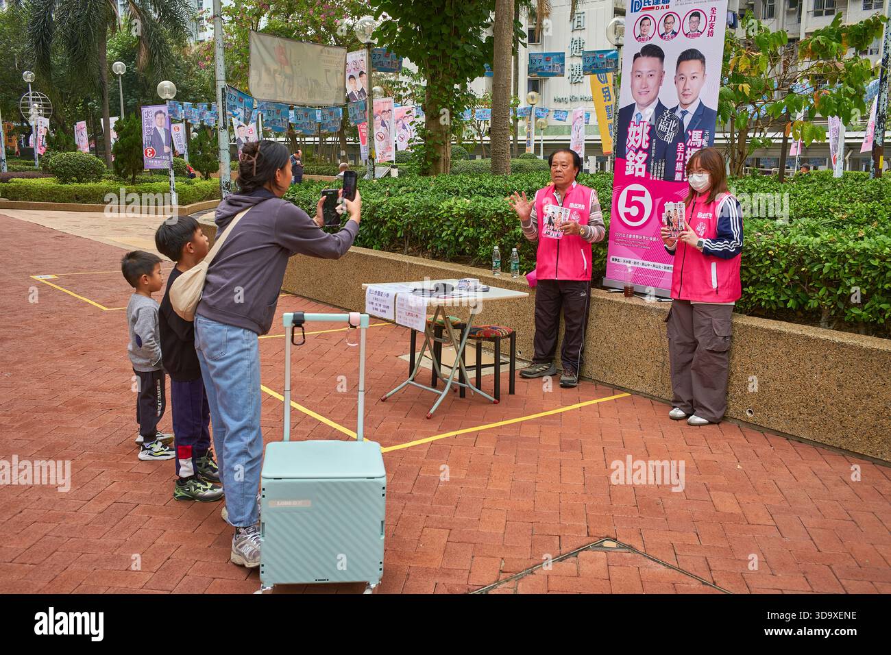 Hongkong, China. Dezember 2025. Die Helfer des Kandidaten werden in der Nähe einer Wahlstation in Tin Shui Wai fotografiert. Die Parlamentswahlen 2025 in Hongkong finden am 7. Dezember 2025 statt, um die 90 Mitglieder des 8. Hongkonger Legislativrates zu wählen. Quelle: SOPA Images Limited/Alamy Live News Stockfoto