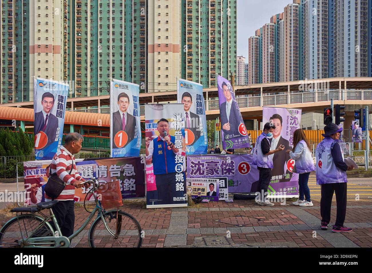 Hongkong, China. Dezember 2025. Der Kandidat verteilt Flugblätter an den Passanten in der Nähe eines Wahlzentrums in Tin Shui Wai. Die Parlamentswahlen 2025 in Hongkong finden am 7. Dezember 2025 statt, um die 90 Mitglieder des 8. Hongkonger Legislativrates zu wählen. Quelle: SOPA Images Limited/Alamy Live News Stockfoto