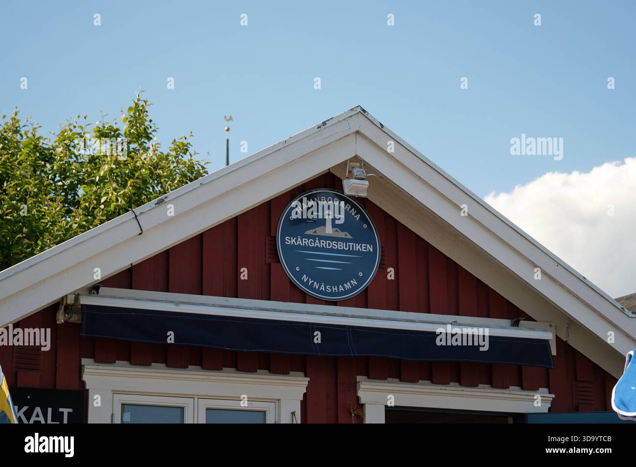 Nynashamn, Stockholmer County, Schweden – 29. Mai 2025: Ein rotes Gebäude mit einem blauen Schild, auf dem Skargardsbutiken in weißen Buchstaben steht. Das Gebäude ha Stockfoto