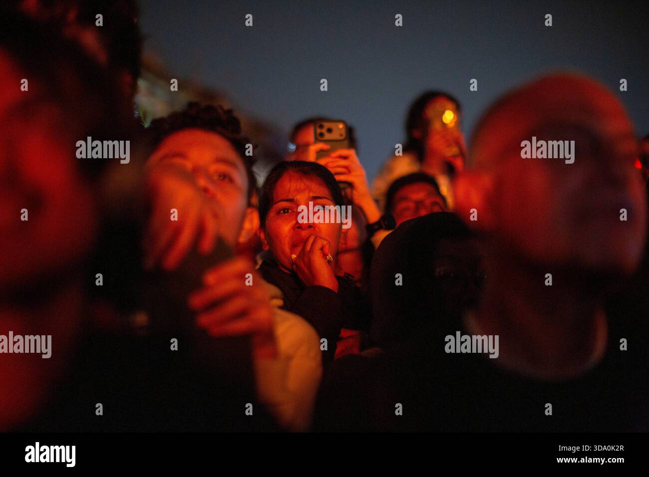 Antigua Guatemala, Sacatepequez, Guatemala. Dezember 2025. Eine Frau mit der Hand, die ihr Gesicht bedeckt, beobachtet, wie die Papierfigur, die als „die drei weisen Teufel“ bekannt ist, während der Verbrennung des Teufels in Antigua Guatemala am Vorabend der Feier der Jungfrau der Unbefleckten Empfängnis brennt, die Feierlichkeiten, die den Beginn des Weihnachtsfestes in Guatemala markieren. (Kreditbild: © Luis Soto/ZUMA Press Wire) NUR REDAKTIONELLE VERWENDUNG! Nicht für kommerzielle ZWECKE! Stockfoto