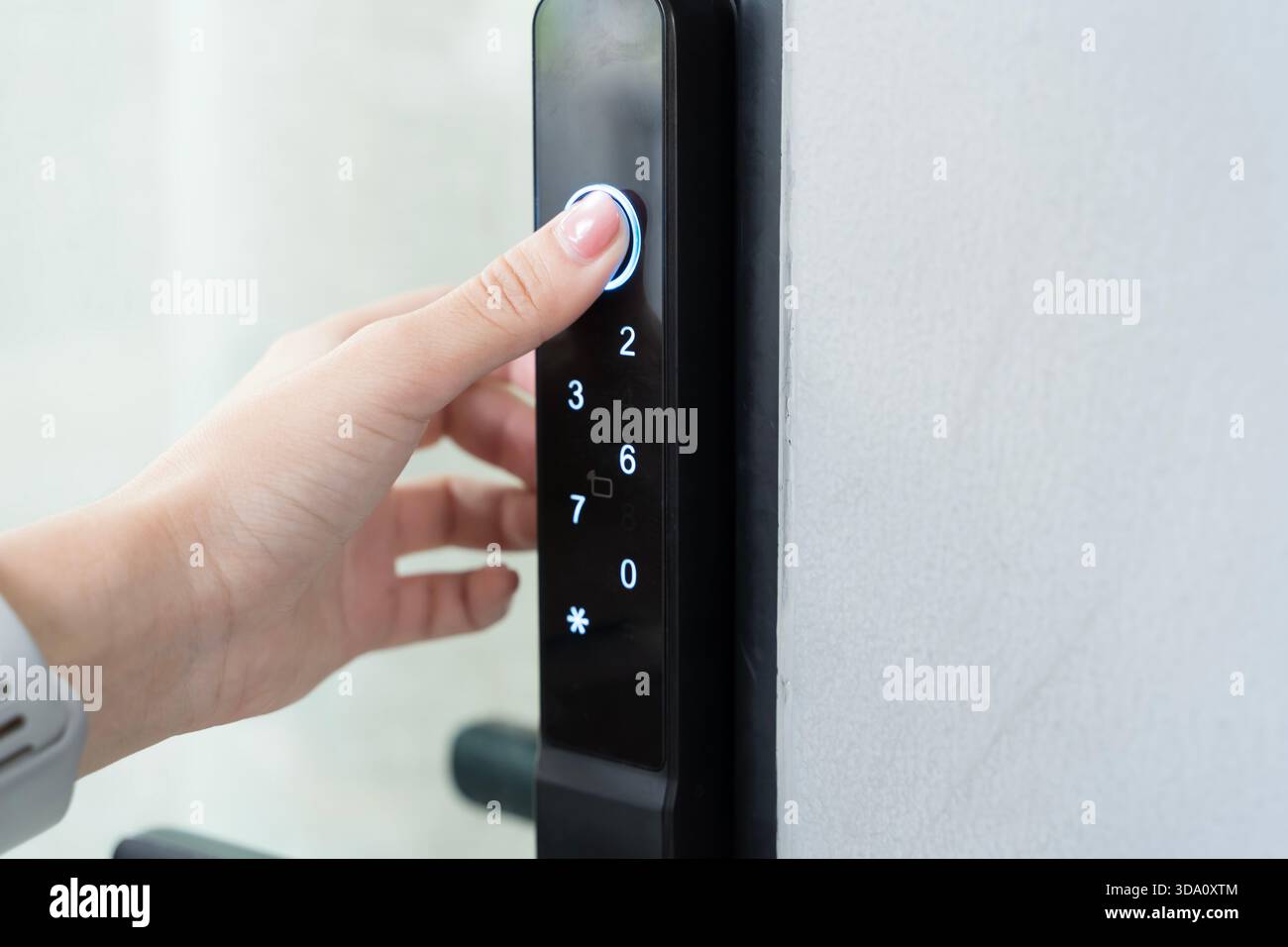 Die beleuchtete Taste auf dem Tastenfeld der intelligenten Türverriegelung symbolisiert den sicheren Zugang und die Sicherheit Schutz Komfort modernes Wohnen Stockfoto