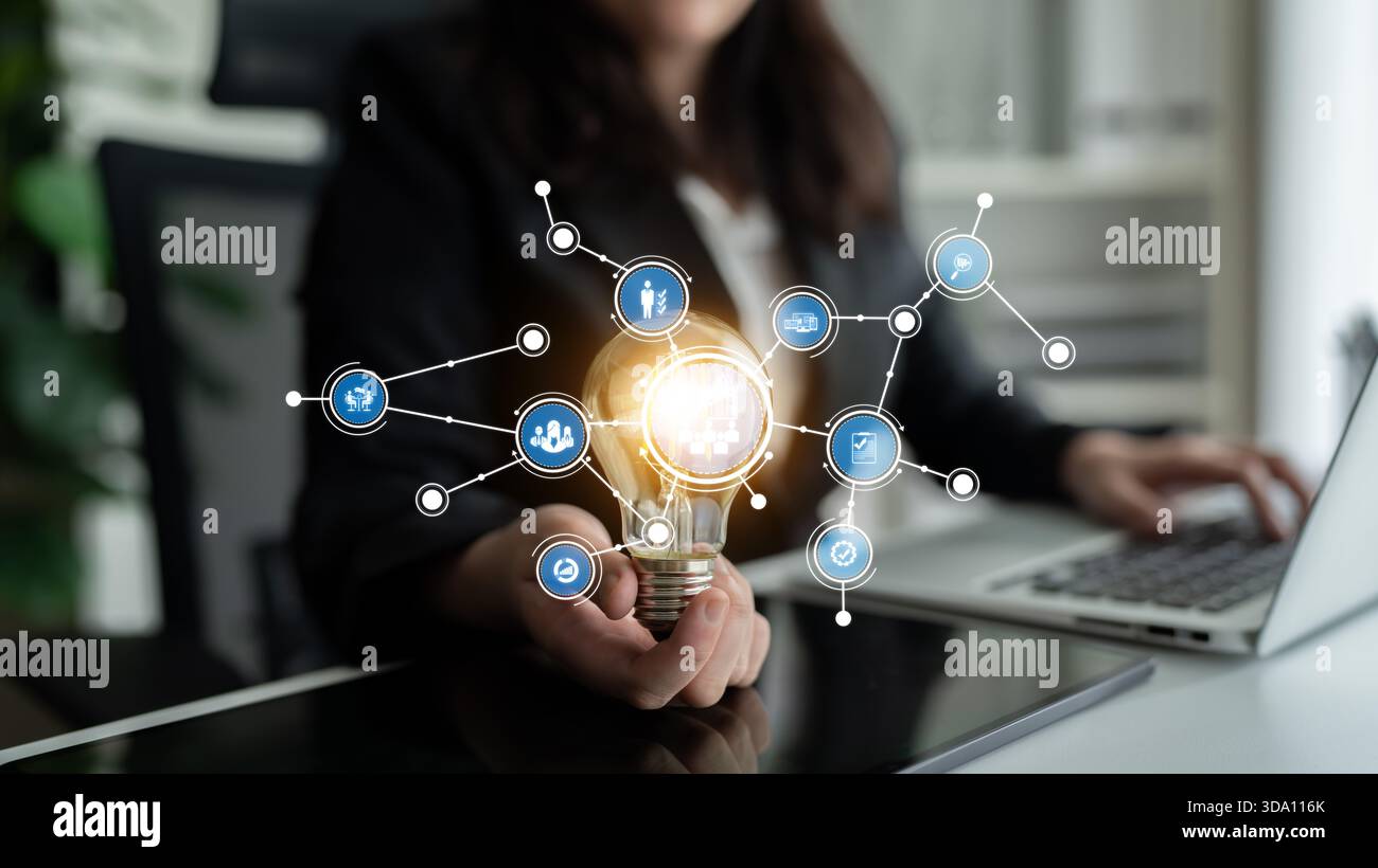 Ein Geschäftsmann veranschaulicht Innovation mit einem Glühbirnensymbol, das Ideen und digitale Elemente verbindet, um Kreativität und Technologie zu repräsentieren Stockfoto