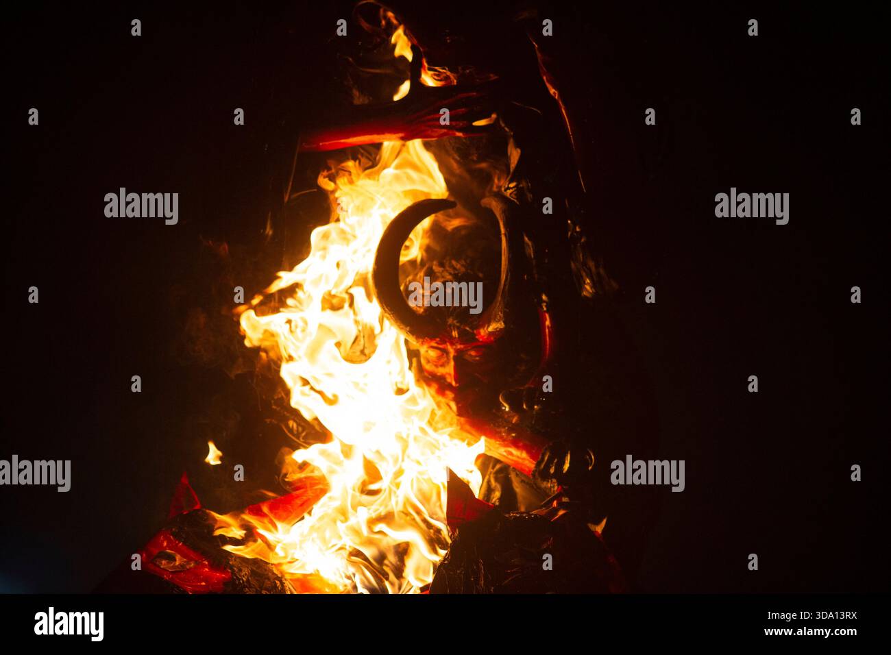 Antigua Guatemala, Guatemala. Dezember 2025. Das Feuer verzehrt die Papierfigur, die als „die drei weisen Teufel“ bekannt ist, während der Verbrennung des Teufels am Vorabend der Feier der Jungfrau der Unbefleckten Empfängnis, Feierlichkeiten, die den Beginn von Weihnachten in Guatemala markieren. Quelle: SOPA Images Limited/Alamy Live News Stockfoto