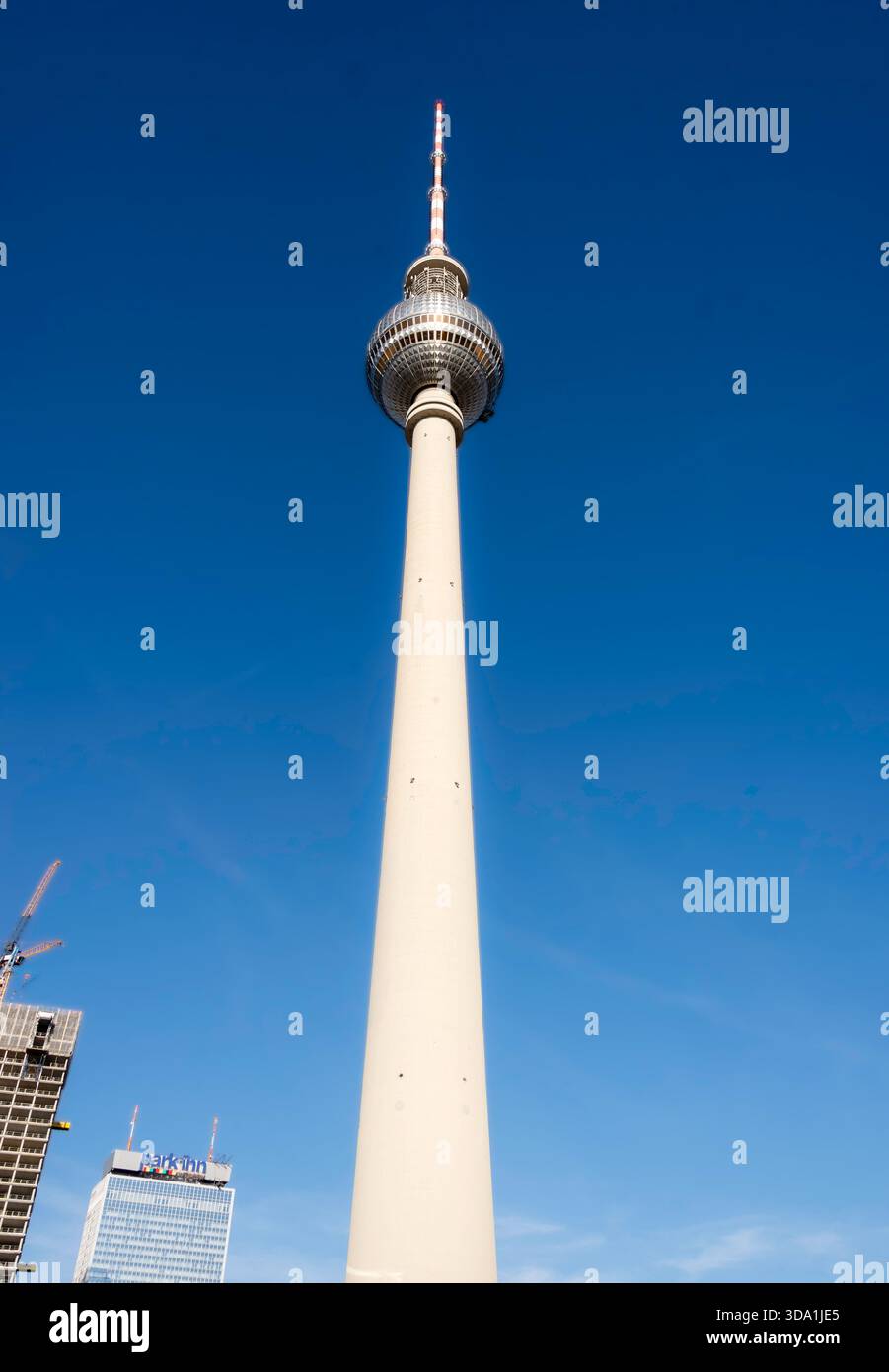 Architektonische Detailansicht des verwitterten Betonschachts und der runden Bullaugenfenster des Berliner Fernsehturms. Brutalistische DDR-Textur. Stockfoto