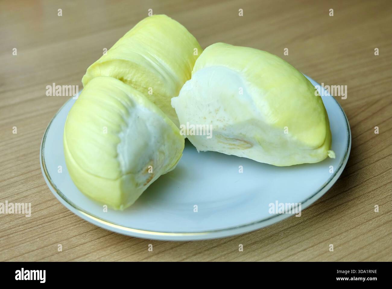 Reichhaltiger, cremiger Durian-Zellstoff auf weißer Platte Stockfoto