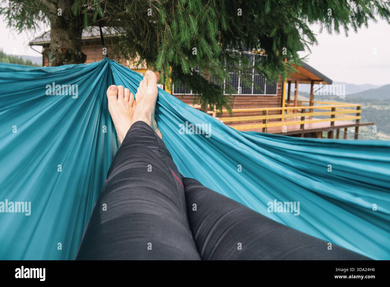 Eine Person, die sich in einer blauen Hängematte entspannt Stockfoto