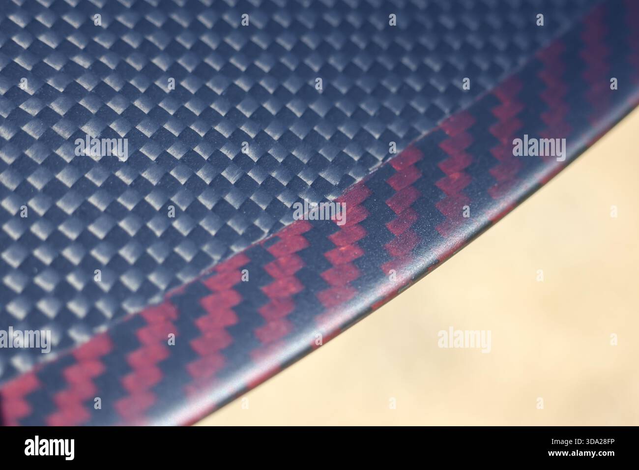 Hintergrund aus roter und schwarzer Kohlefaser mit modernem, schlanken Muster. Dieses Hochleistungs-Verbundmaterial steht für fortschrittliche Technologie und Stockfoto