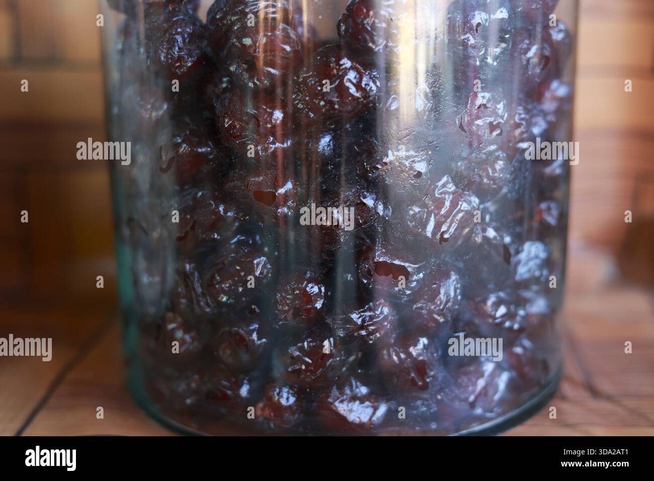 Nahaufnahme eines rustikalen Glasgefäßes voller süßer getrockneter Kirsche. Köstliches hausgemachtes Essen, natürliche Bio-Zutat für gesunde Ernährung, konserviert auf Holz b Stockfoto