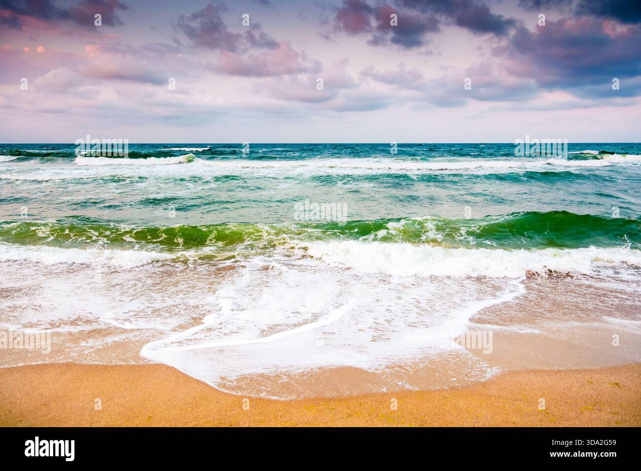 Schwarze Meereswellen stürzen auf den Sandstrand bulgariens. Sommerurlaub an einem windigen Tag unter dunklem bewölktem Himmel. Blick auf die dramatische Meereslandschaft. Hintergrund Stockfoto