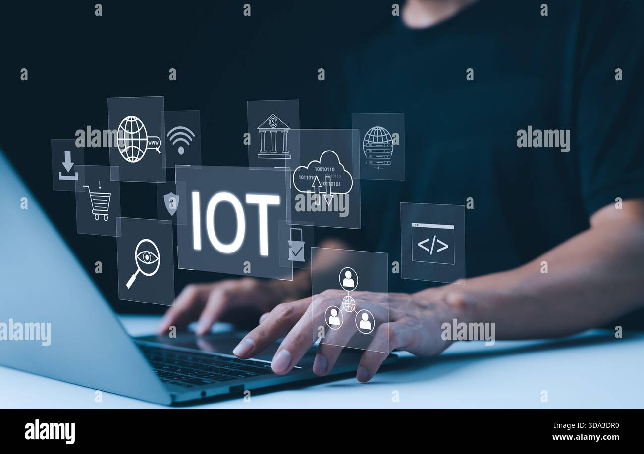 IoT-Konzept. Internet der Dinge. Eine Person, die an einem Laptop mit digitalen Symbolen arbeitet, die das Internet der Dinge (IoT) repräsentieren und moderne Technologie demonstrieren Stockfoto