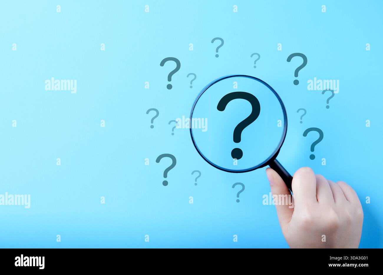 Konzept der Fragezeichen- und Ursachenanalyse. Eine Hand, die eine Lupe über einem großen Fragezeichen hält, umgeben von kleineren auf blauem Hintergrund Stockfoto