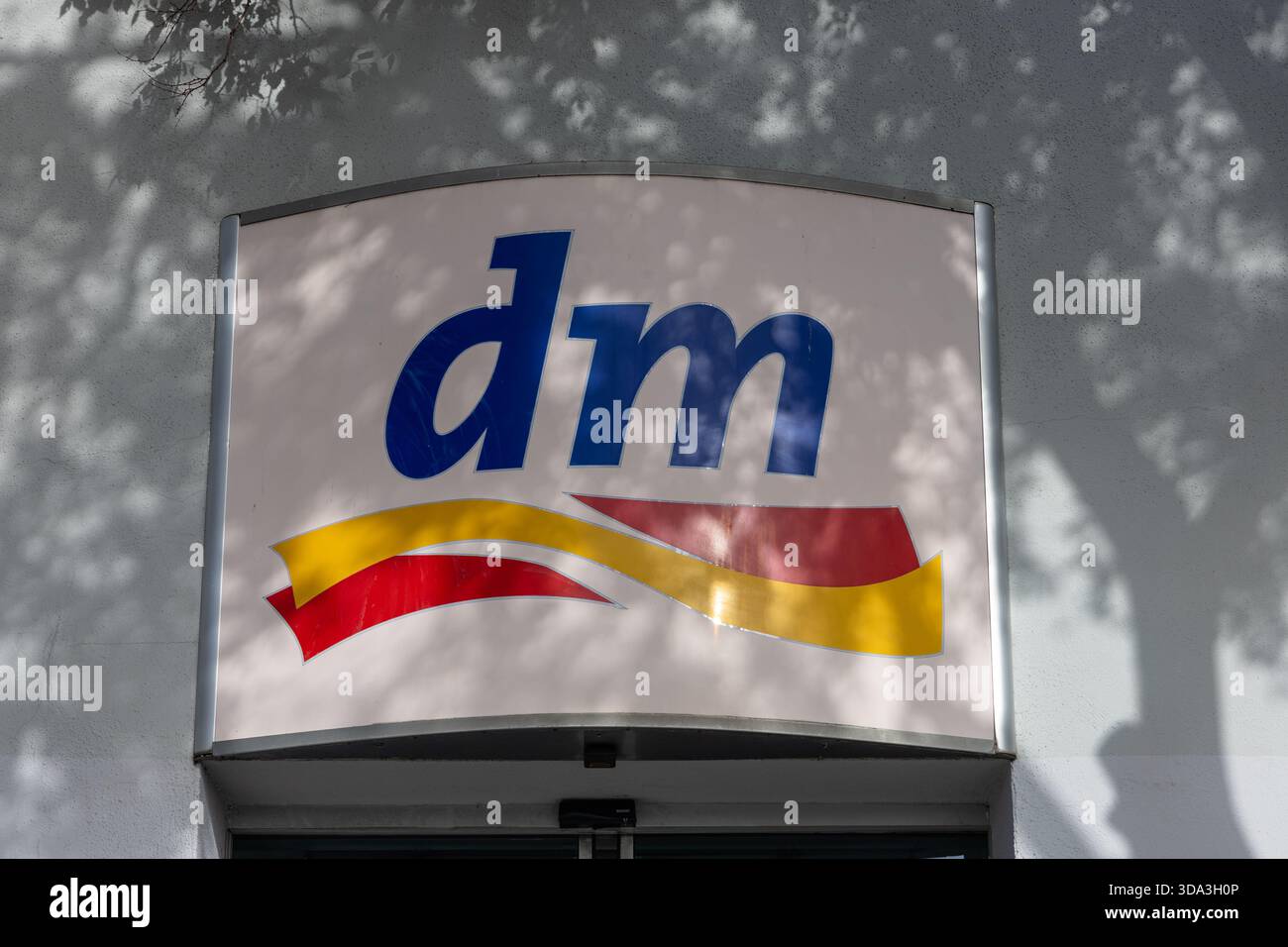 SPLIT, KROATIEN, 10.25.2025: Ein Schaufensterschild mit dem blauen „dm“-Logo mit einem schwungvollen gelben und roten Schleifenmotiv. Diese Bildkappe für das Einzelhandelsbranding Stockfoto