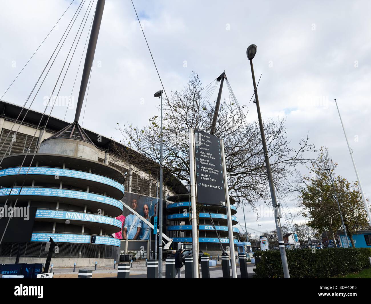 Manchester, Großbritannien - 16. November 2025: Außenansicht des Stadions von Manchester mit blauen Bannern und Stadtbeschilderungen. Stockfoto