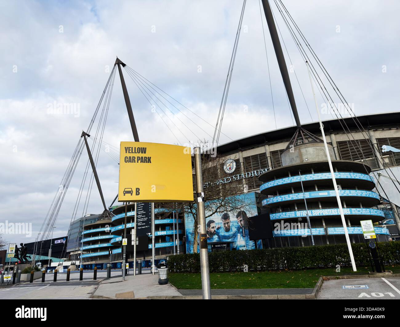 Manchester, Großbritannien - 16. November 2025: Helle Stadionszene mit gelbem Parkplatzschild vor einem modernen Veranstaltungsort in Manchester, urbaner Look. Stockfoto