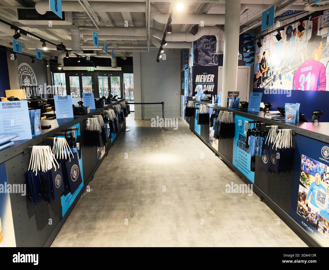 Manchester, Großbritannien – 16. November 2025: Lebhafter Stadionshop mit blauem Branding, der Kleidung und Accessoires verkauft. Stockfoto