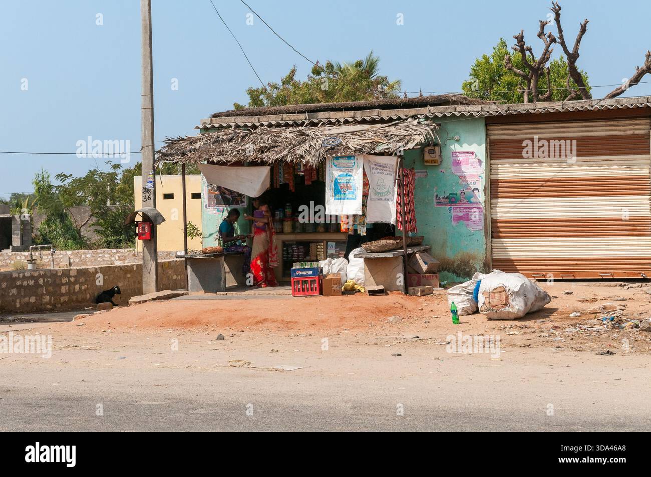 Puttaparthi, Andhra Pradesh, Indien - 11. Januar 2013: Kleiner Straßenladen, der Snacks, Speisen, Getränke und kleine Artikel mit einem Verkäufer und einem Käufer verkauft Stockfoto