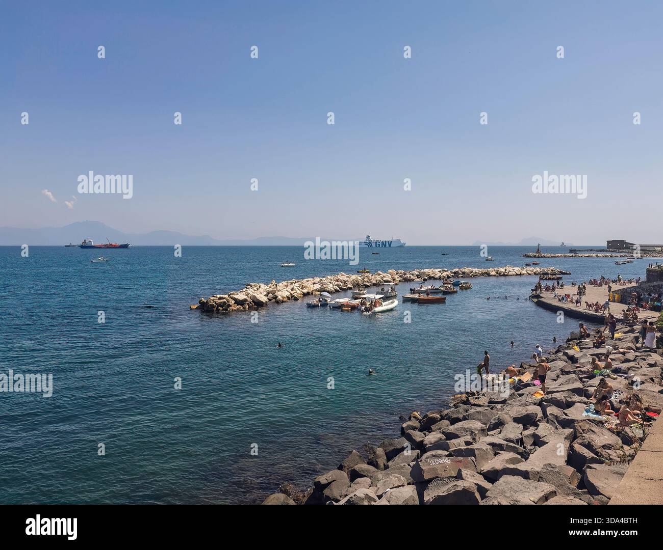 Neapel – 17. Juli 2024: Grandi Navi Veloci (GNV) ist ein italienisches Fährschiff, das den Hafen verließ. Ein anderer Frachter dahinter, von der Via Nazari aus gesehen Stockfoto