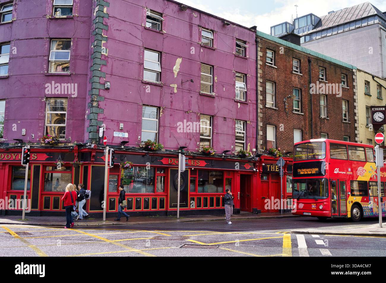 Straßenszene in Dublin, Irland, mit einem farbenfrohen Pub und einem roten Doppeldeckerbus. Dublin, Irland, 8. 08. 2025 Stockfoto