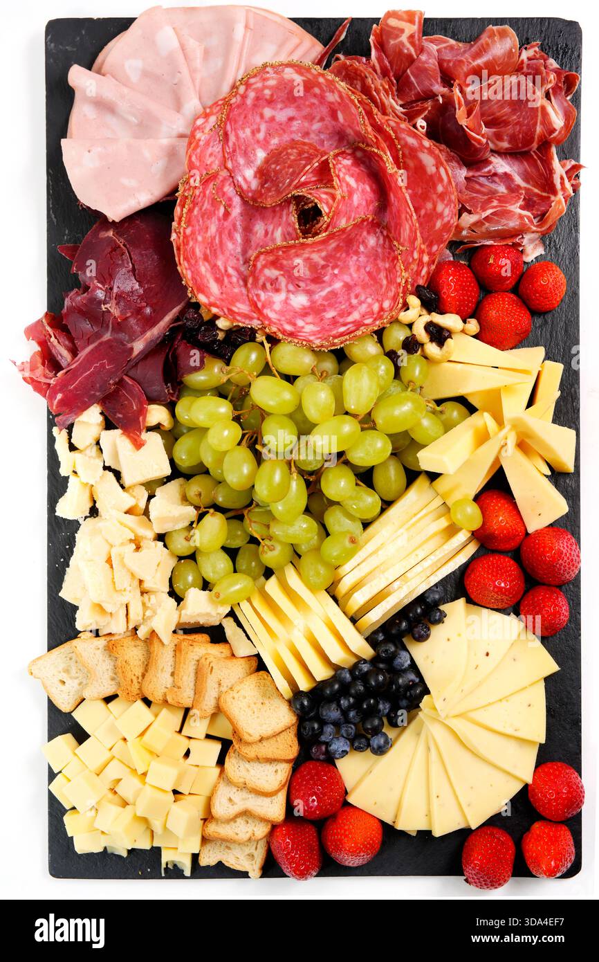 Gourmet-Wurstplatte mit einer Auswahl an Fleisch, Käse, Trauben, Erdbeeren und Toast als Vorspeise Stockfoto