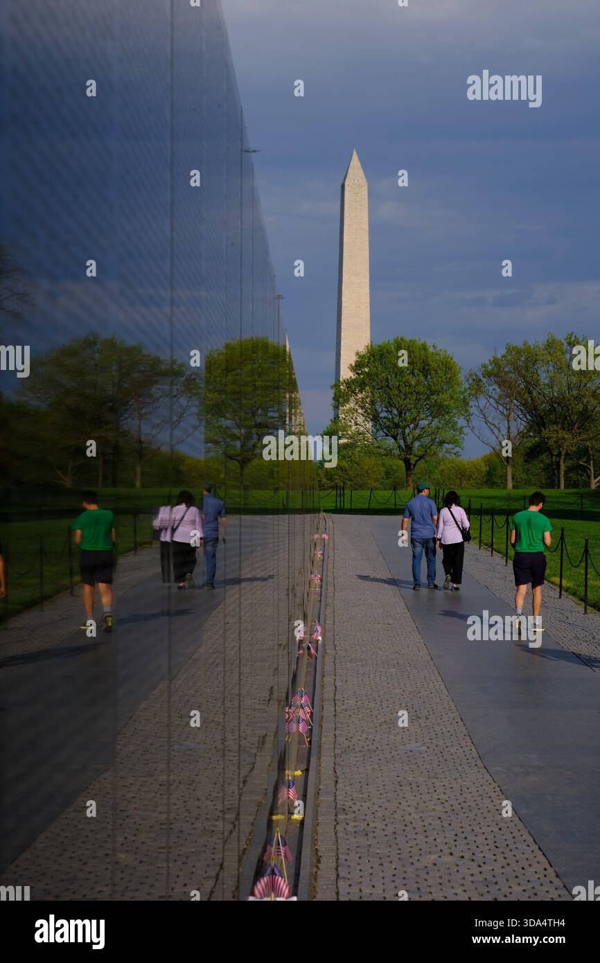 Vietnam Veterans Memorial Wall Perspektive mit Washington Monument im Hintergrund, Washington DC Stockfoto