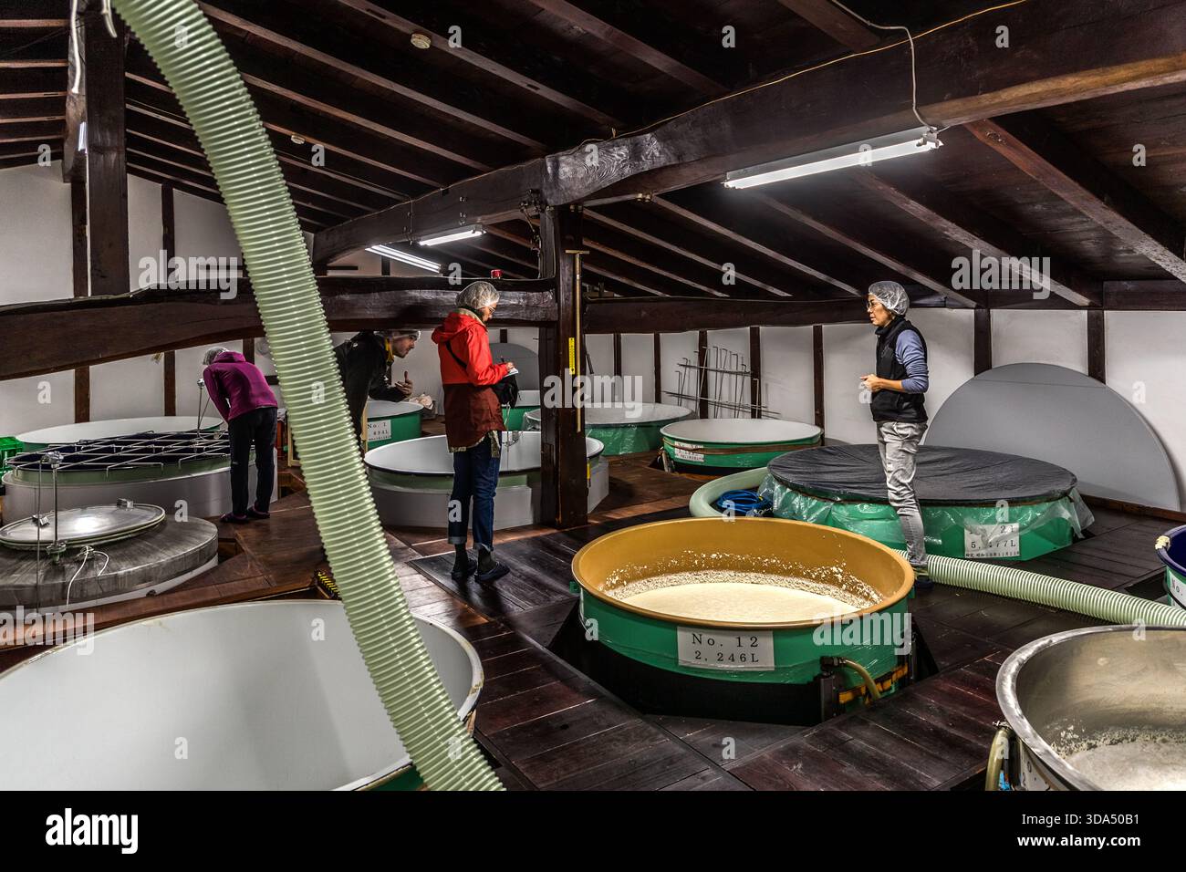 Blick in den Gärraum einer Sake-Brauerei im Kiso-Tal, Präfektur Nagano: Offene Gärbehälter, inkl. mwst.-Nr. 12 mit einem Fassungsvermögen von 2.246 Litern enthält Sake-Maische (Moromi) in verschiedenen Gärstufen. Das historische Gebäude mit freiliegenden Holzbalken ist typisch für traditionelle japanische Sake-Brauereien (酒蔵). Kiso, Präfektur Nagano, Japan Stockfoto