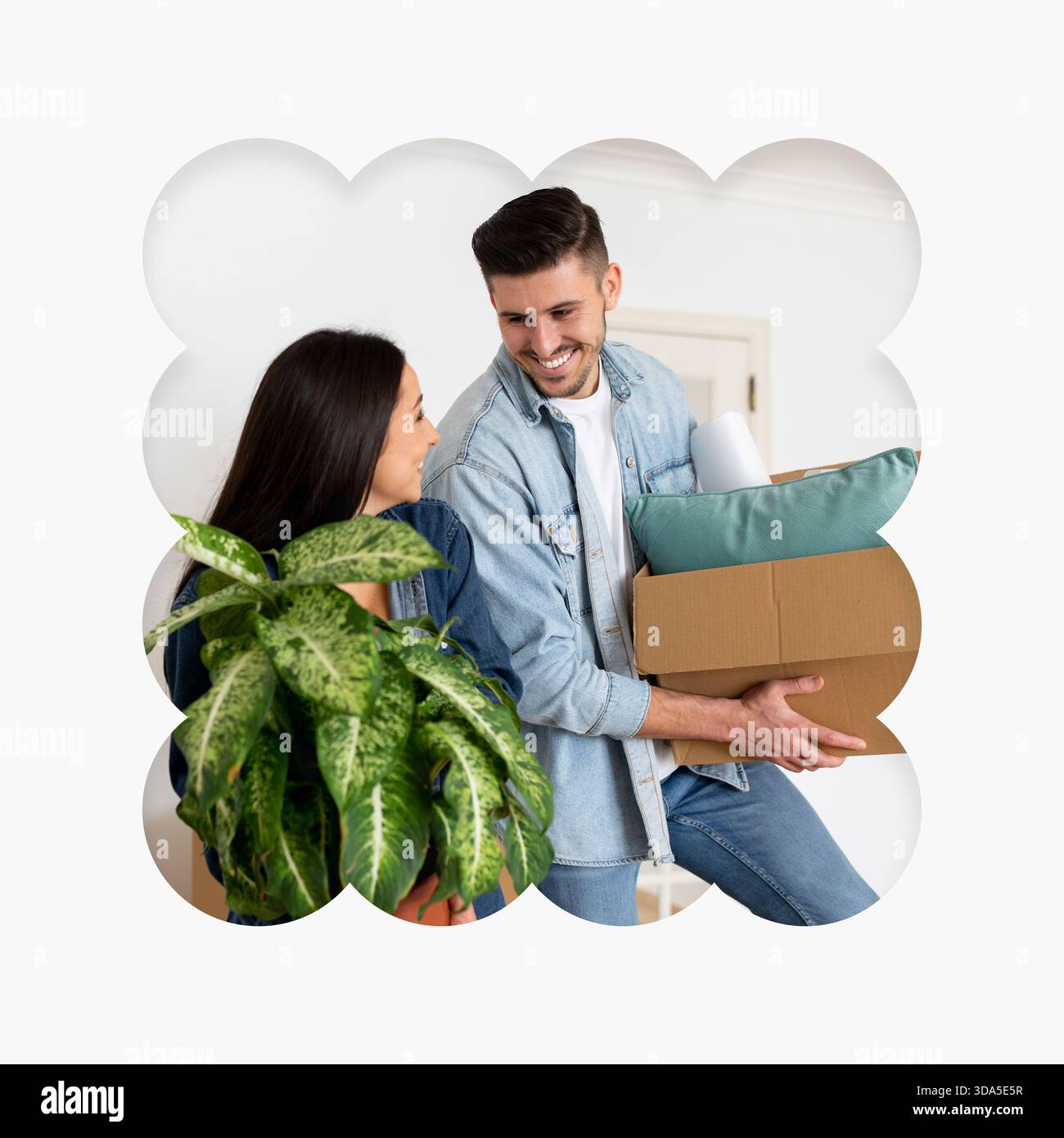 Glückliches Paar zieht in ein neues Zuhause mit Pflanzen und Kisten in einem hellen Raum Stockfoto